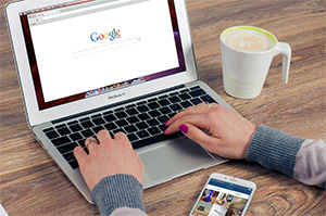 Person using laptop with search engine window open prepared to type in a key term highlighting why SEO Ocean County services are so important