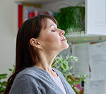 Person inhaling clean indoor air after duct cleaning in Ocean County