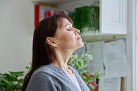 Person inhaling clean indoor air after duct cleaning in Ocean County