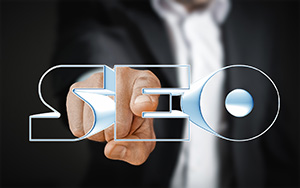 Blurred background of person in a suit with one finger extended towards text reading SEO; SEO Ocean County graphic