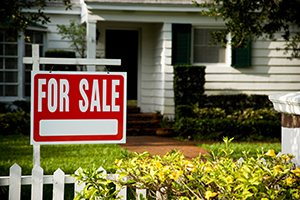 For Sale sign outside home with neatly trimmed trees by tree companies in Smithville